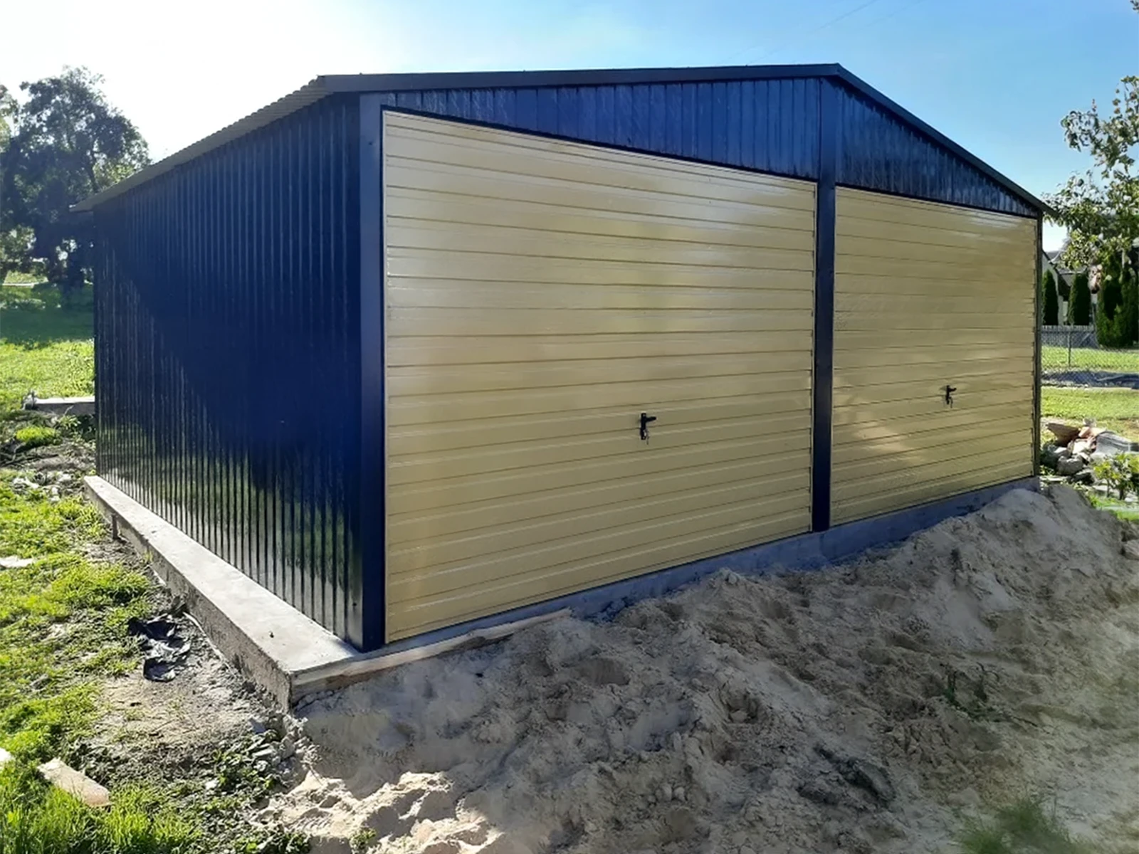 Garage antracite a due posti auto con porte basculanti color sabbia